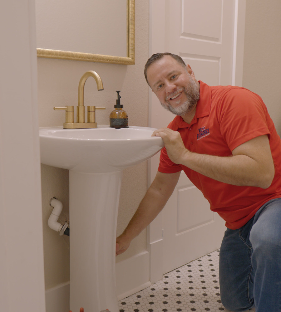 A We The Plumbers plumber smiling in a customer's bathroom